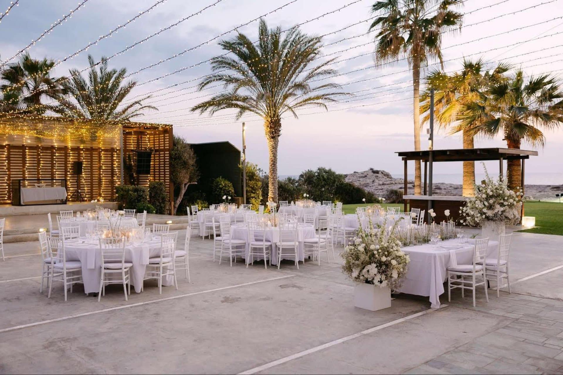 Reception terrace at Alassos at sunset with palm trees and fairy lights