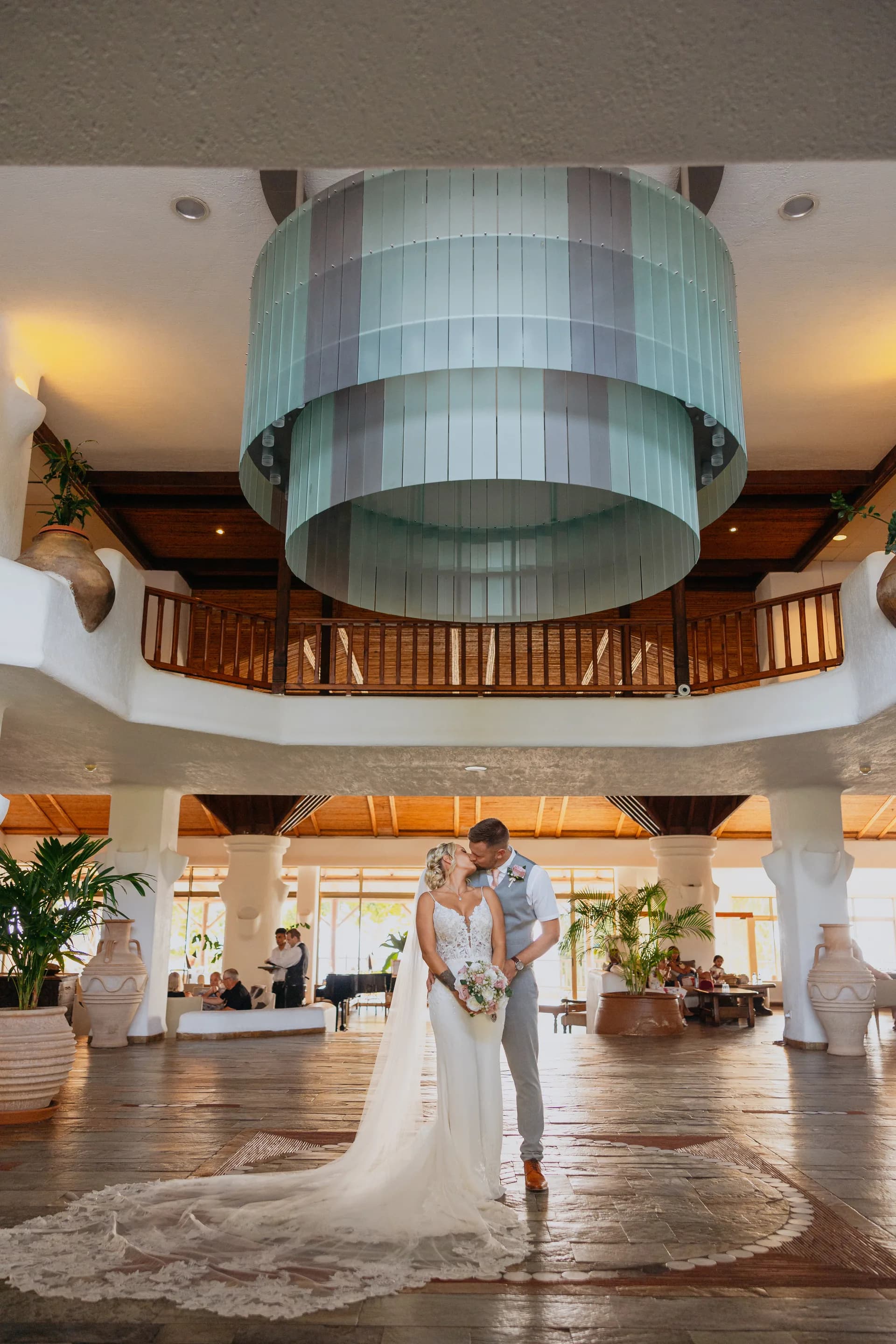 Couple in the atrium lobby at Coral Beach beneath its ribbed circular ceiling drum and timber galleries