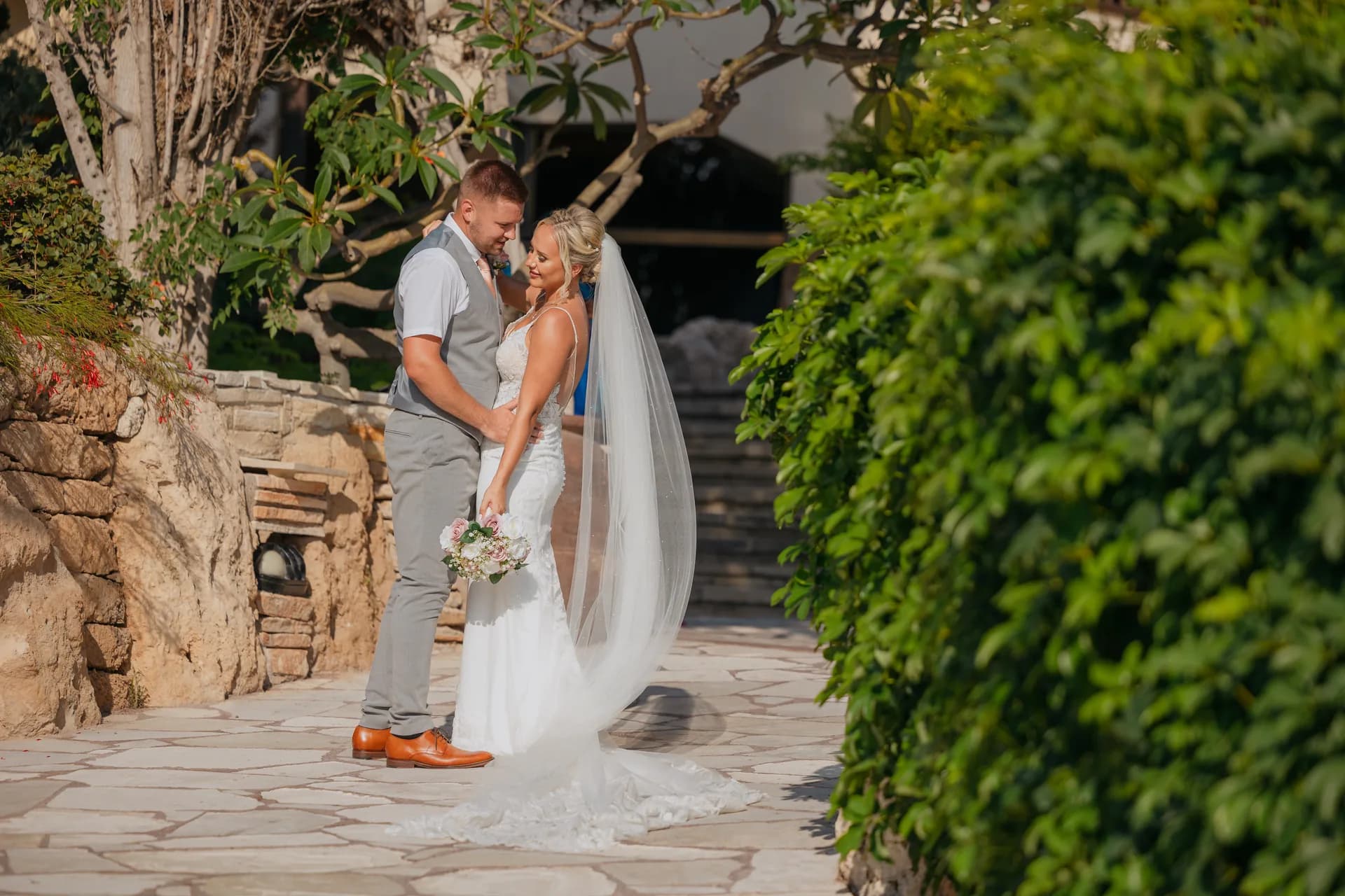 Couple on a flagstone garden path at Coral Beach among mature trees and dense greenery