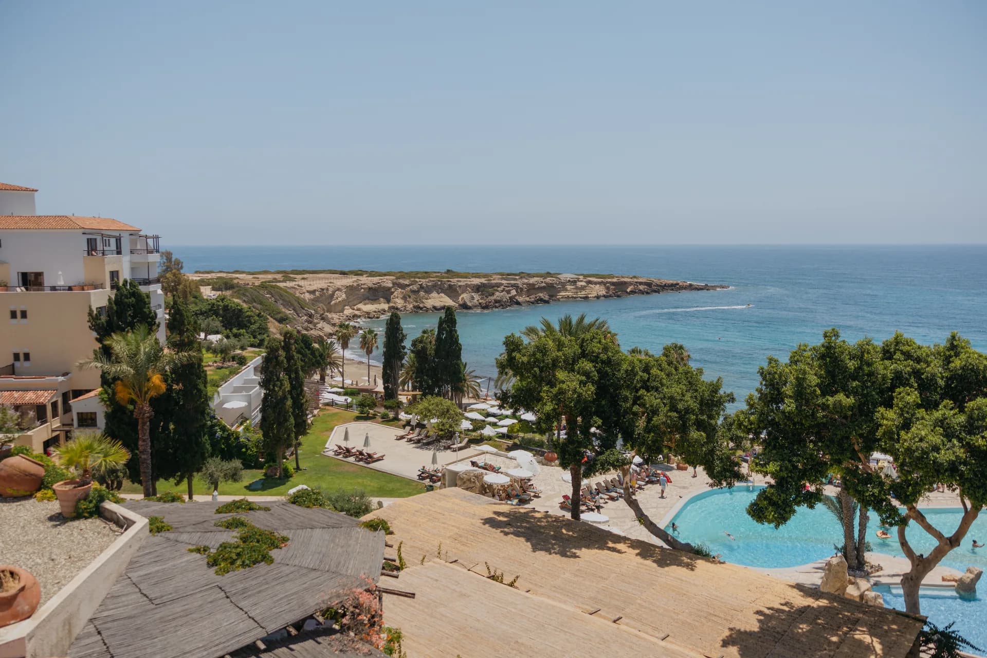 Elevated view over the pool, palms and loungers at Coral Beach out to Coral Bay