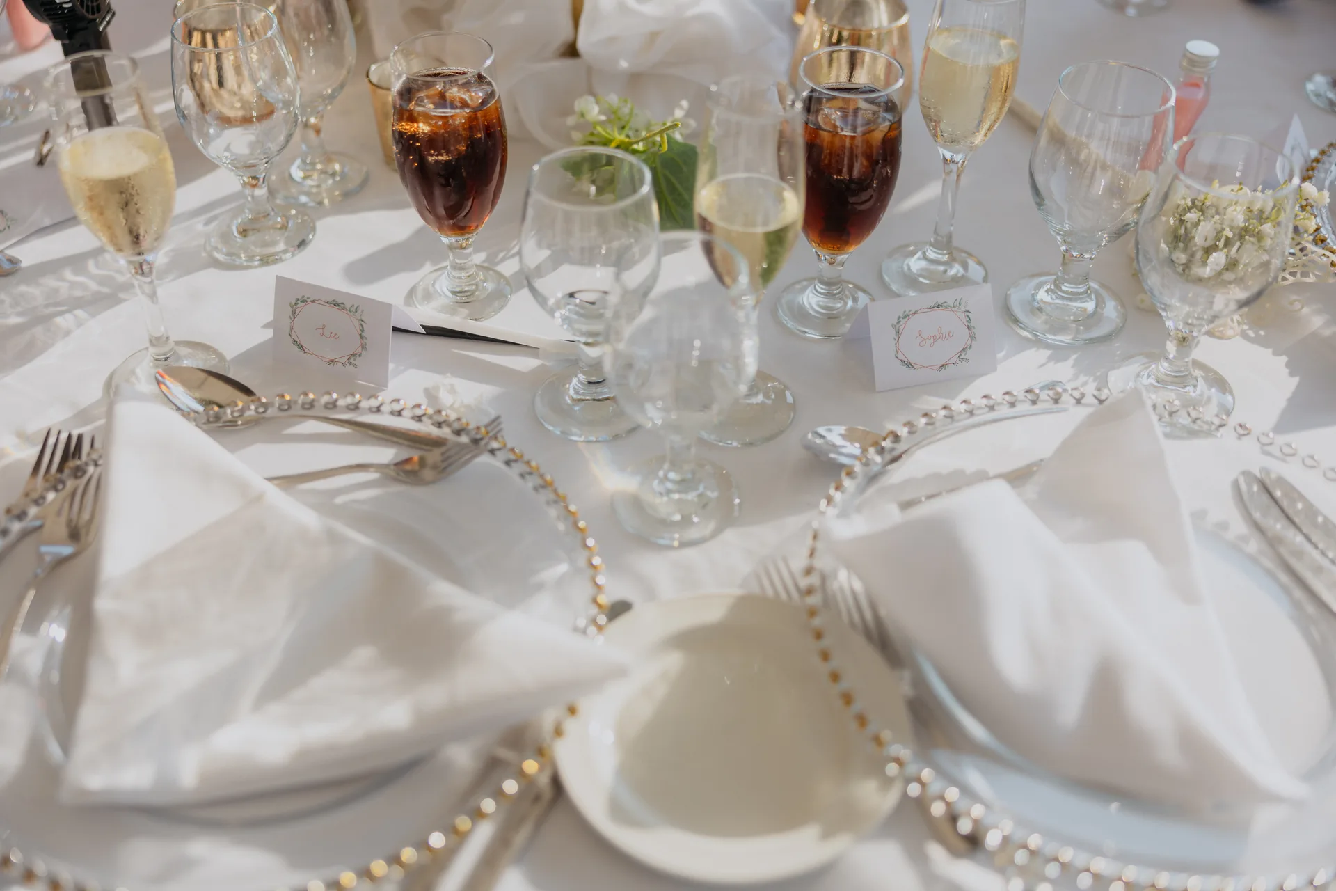 Close detail of a place setting at Coral Beach with pearl charger, folded linen and glassware