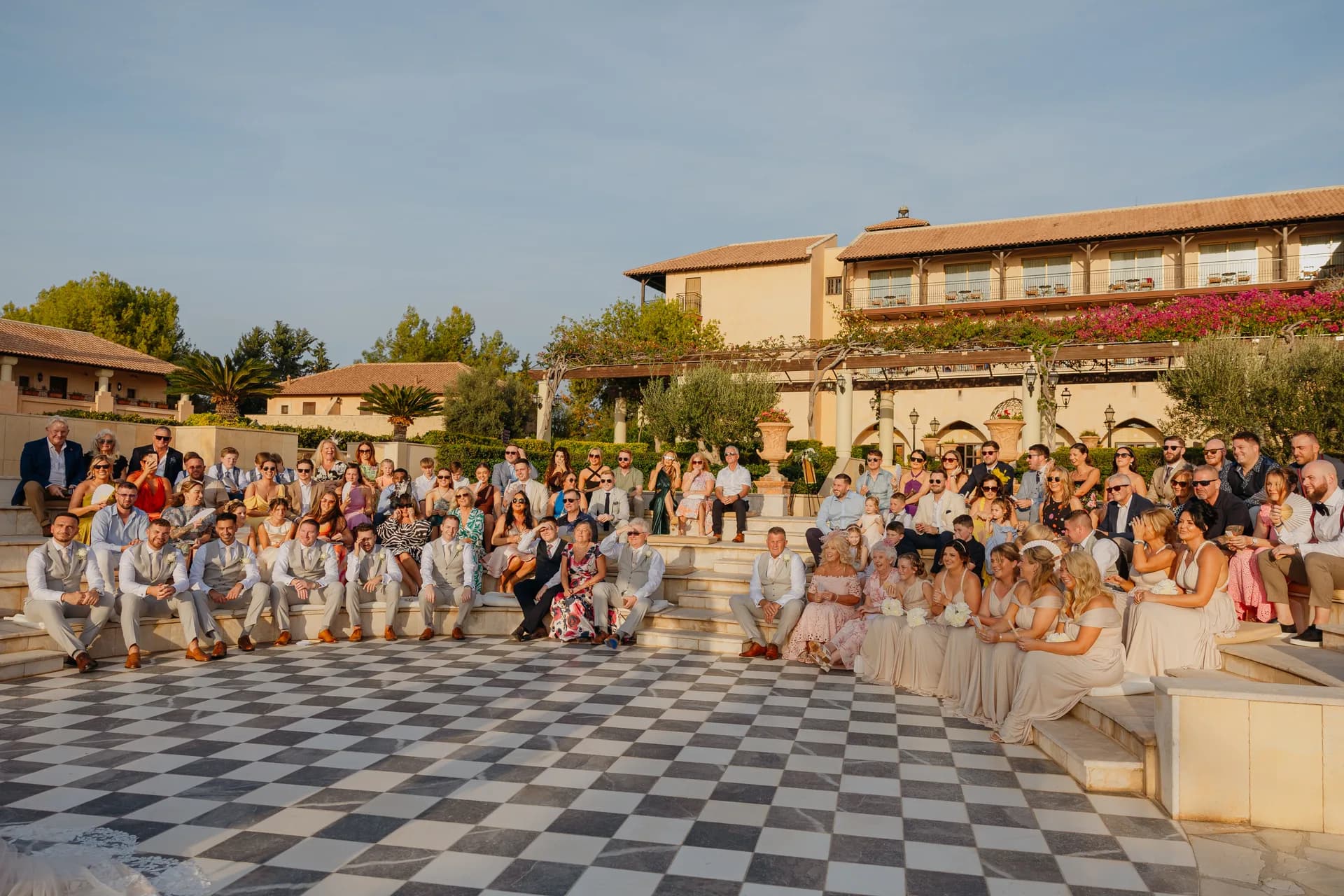 Wedding guests filling the tiered stone seating around the Elysium’s chequerboard ceremony terrace