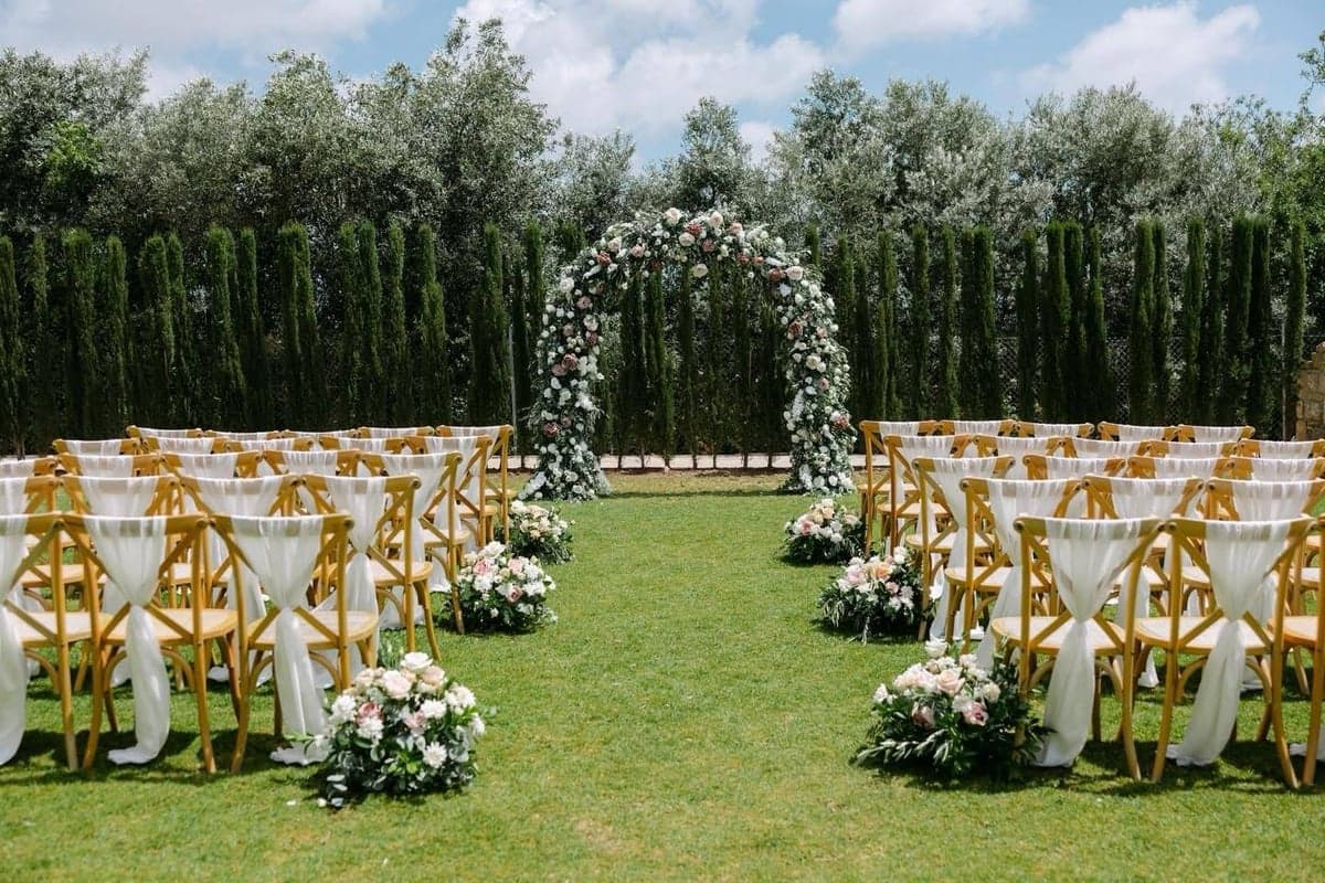 Ceremony aisle with pink floral arch at L'Chateau estate, Paphos