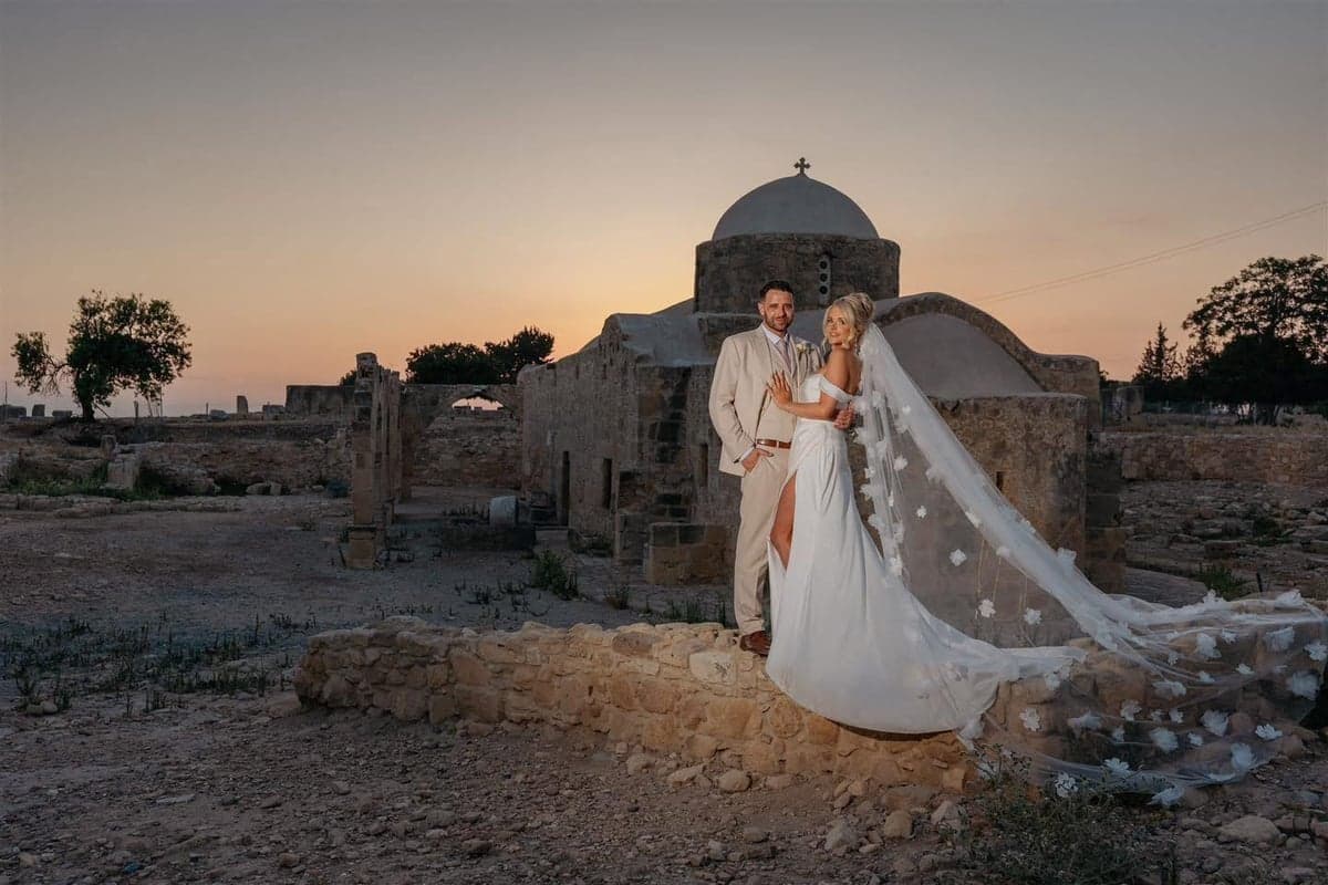Couple silhouette at sunset beside an ancient Paphos church