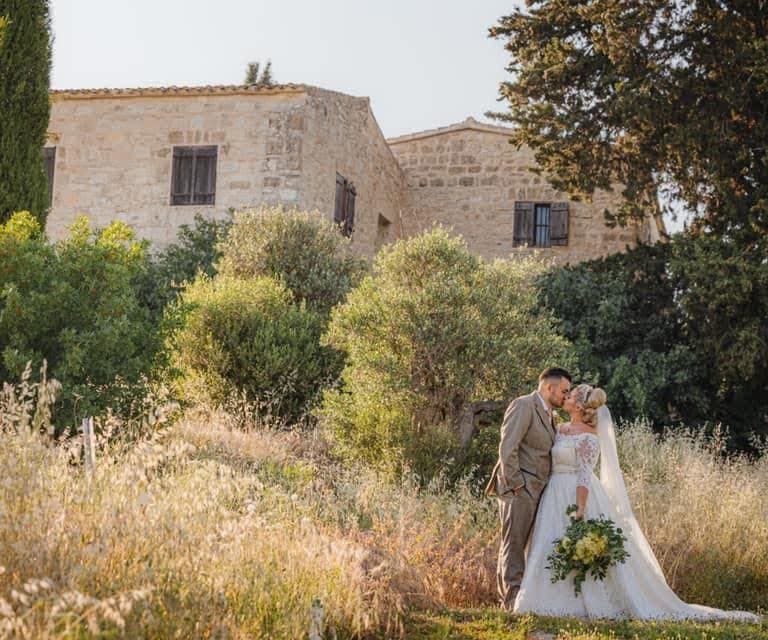 First kiss under ceremony arch at Minthis Hills, Tsada