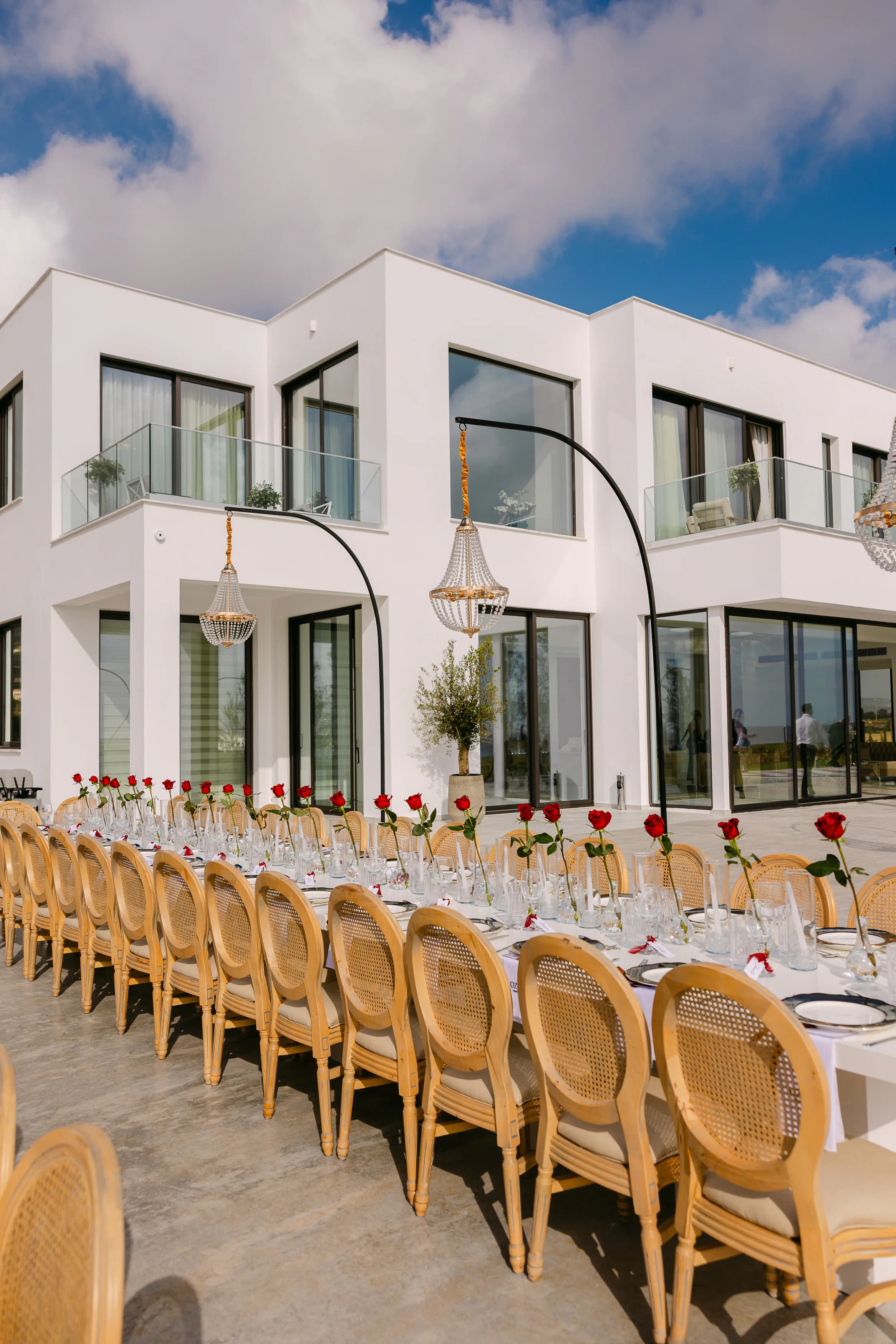 OZEA wedding reception table viewed against the contemporary white villa architecture in Sea Caves Paphos