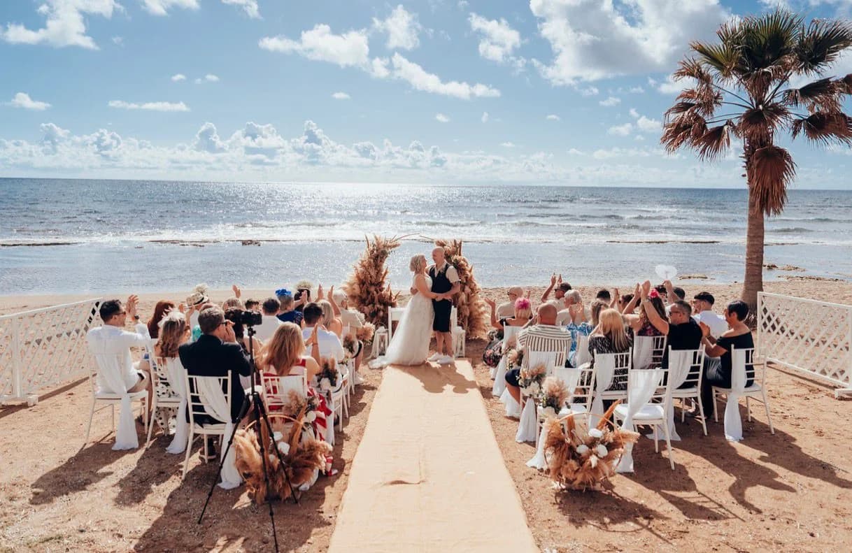 Wedding ceremony guests by the sea at Kefalos Beach