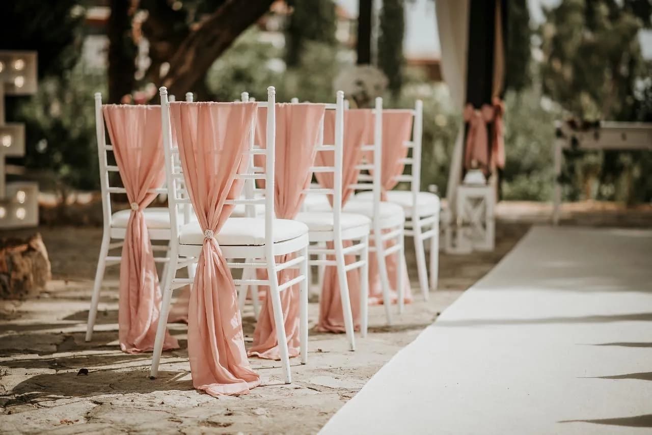 Garden ceremony chairs beneath the pergola at Pegia Gardens