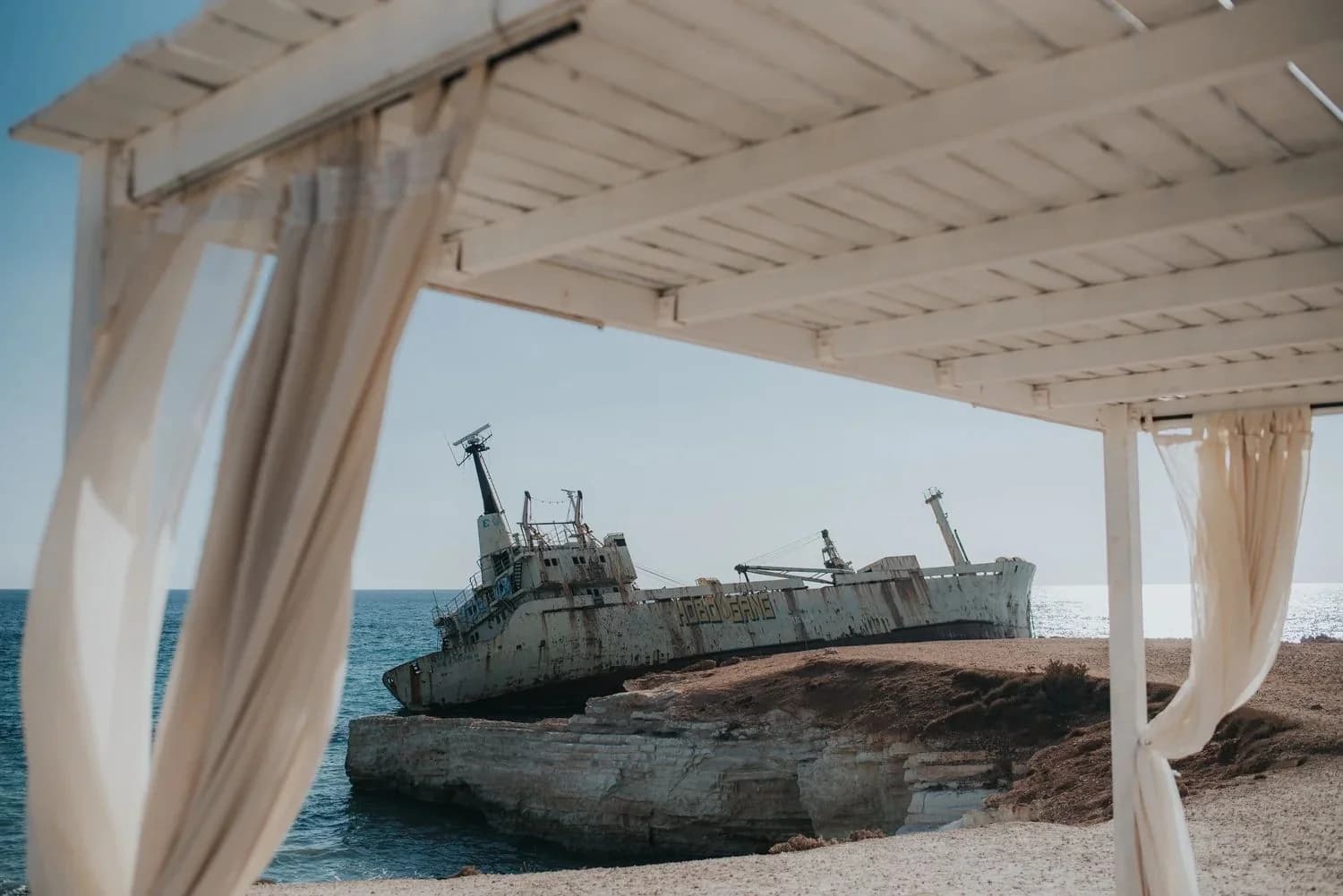 Shipwreck in the sea beside a covered ceremony terrace