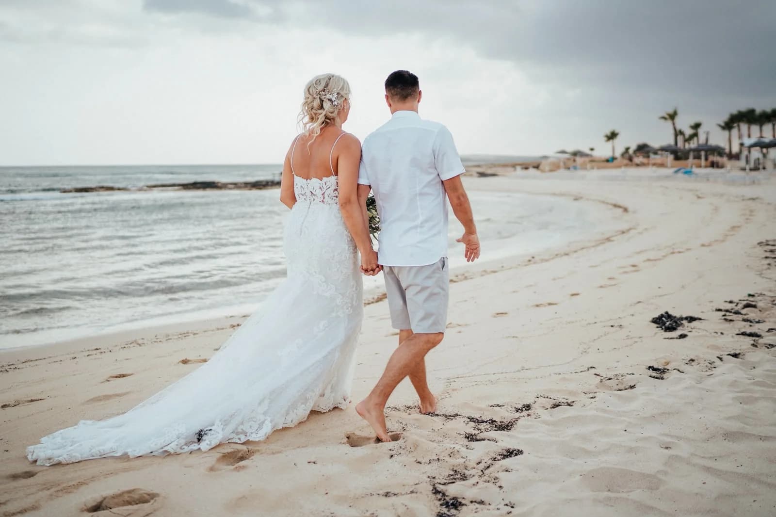 Couple walking along Sirenes Beach
