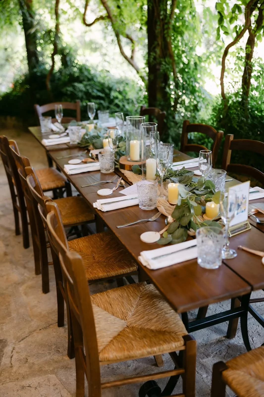 Outdoor reception table beneath trees at Vasilias