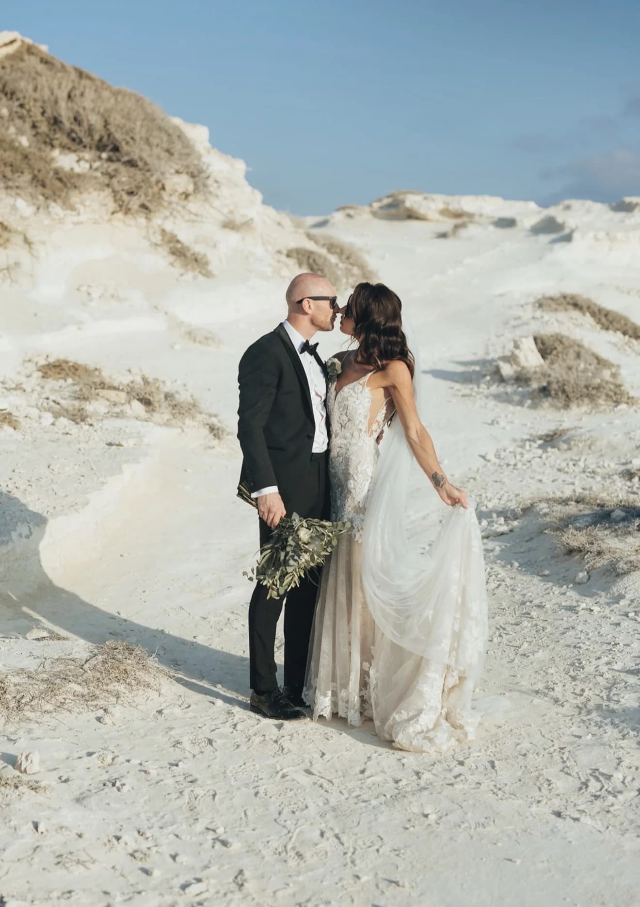 Newlyweds standing together at the foot of the white cliffs