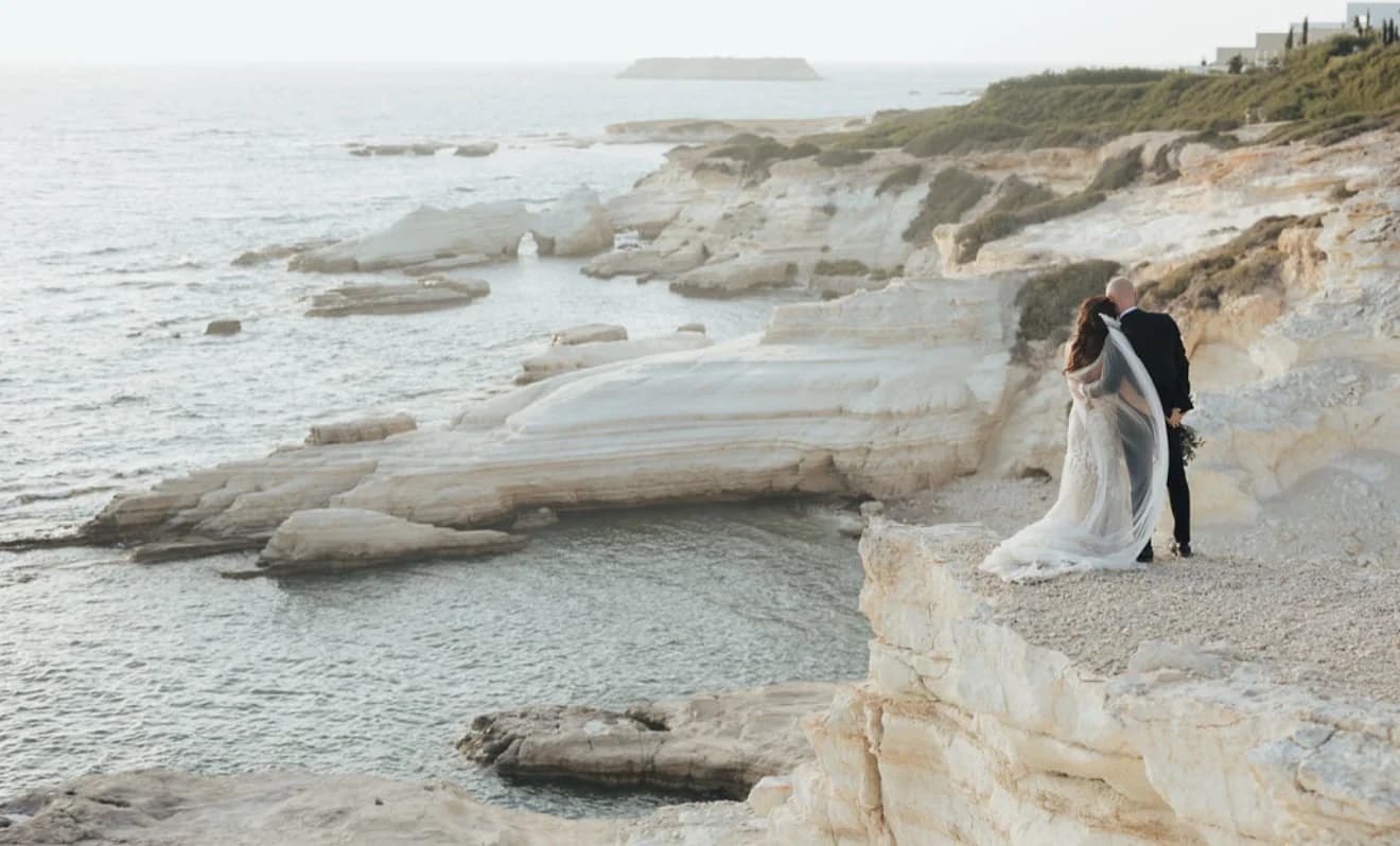 Couple together on a pale rocky shoreline above the sea at White Cliffs