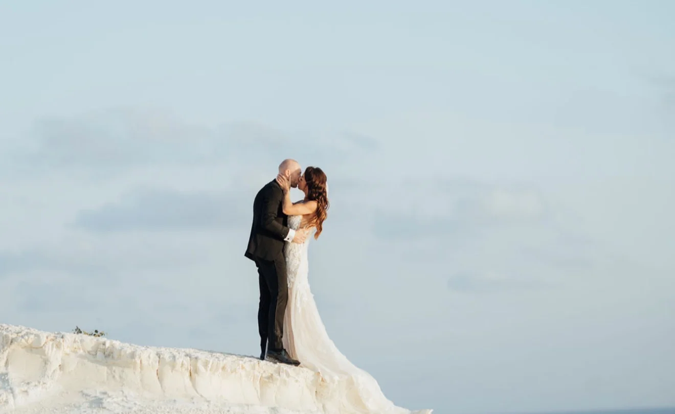 Couple embracing against the open sky above the cliffs
